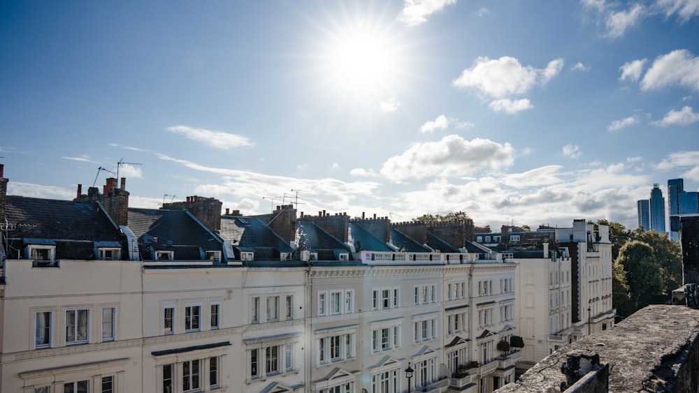 the sun is shining over a row of buildings