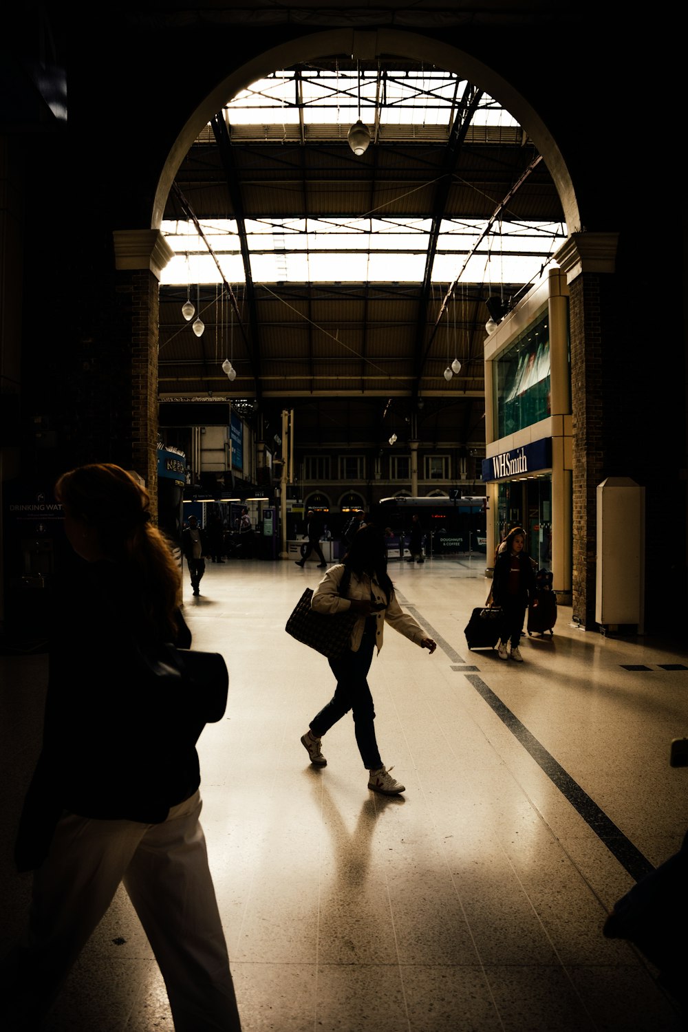 a group of people walking through a train station