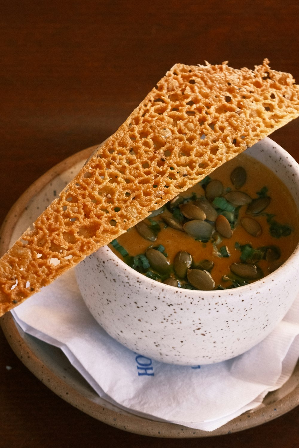 a bowl of soup with a piece of bread sticking out of it