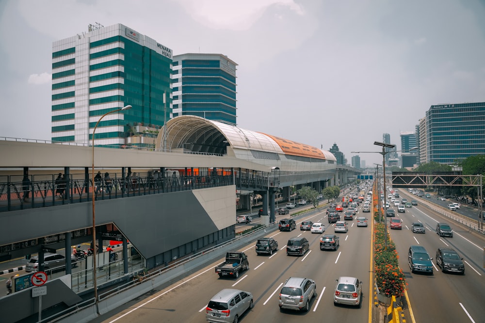 a city street filled with lots of traffic next to tall buildings