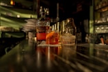 A dimly lit vintage bar corner with a worn wooden table and a glass of whiskey, smoke curling in the air.