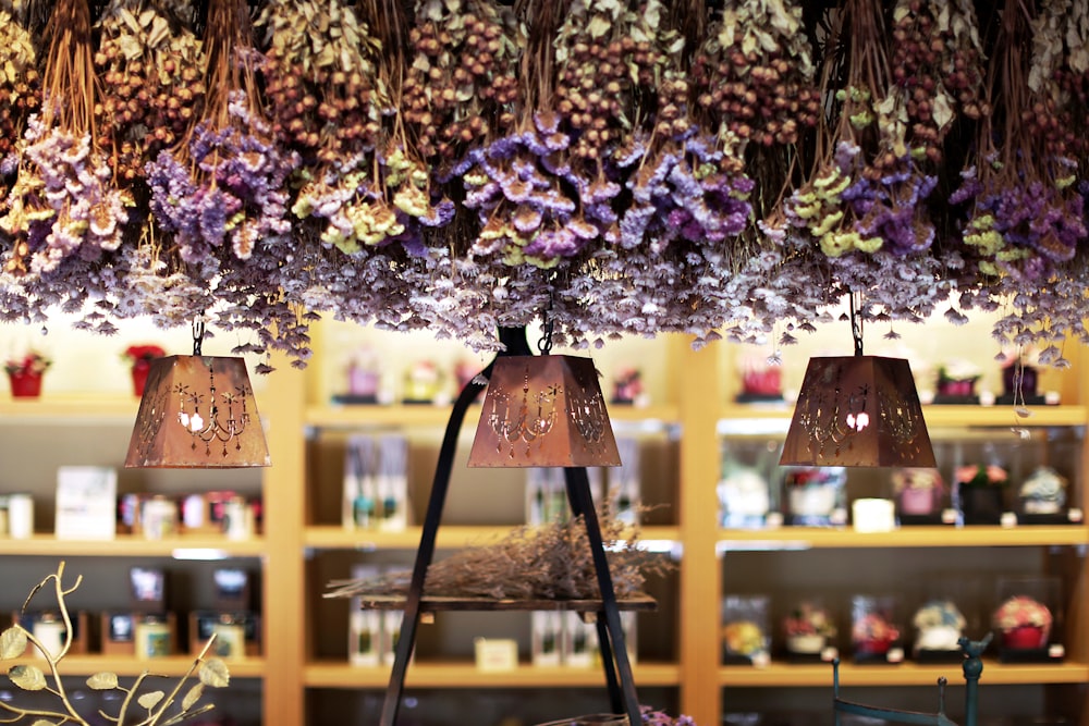 a bunch of purple flowers hanging from a ceiling