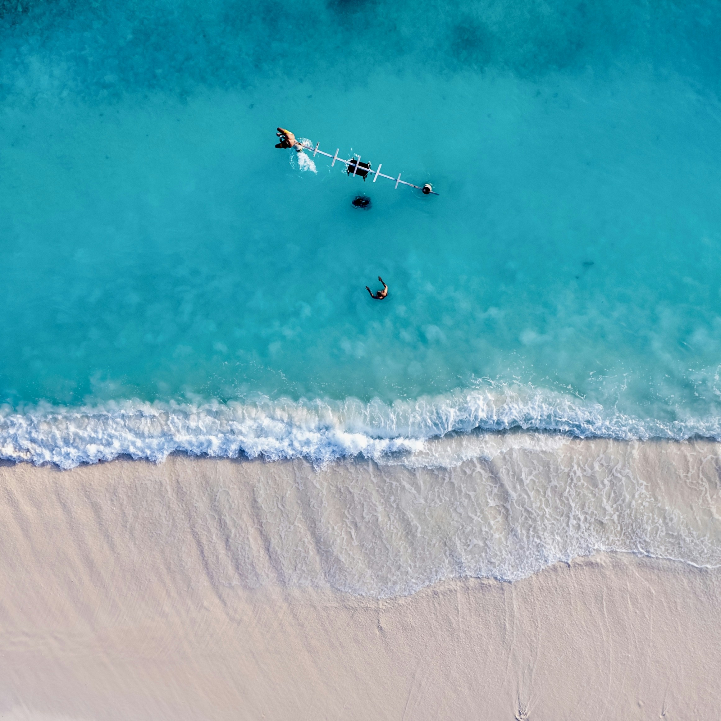 two people are in the water on a beach