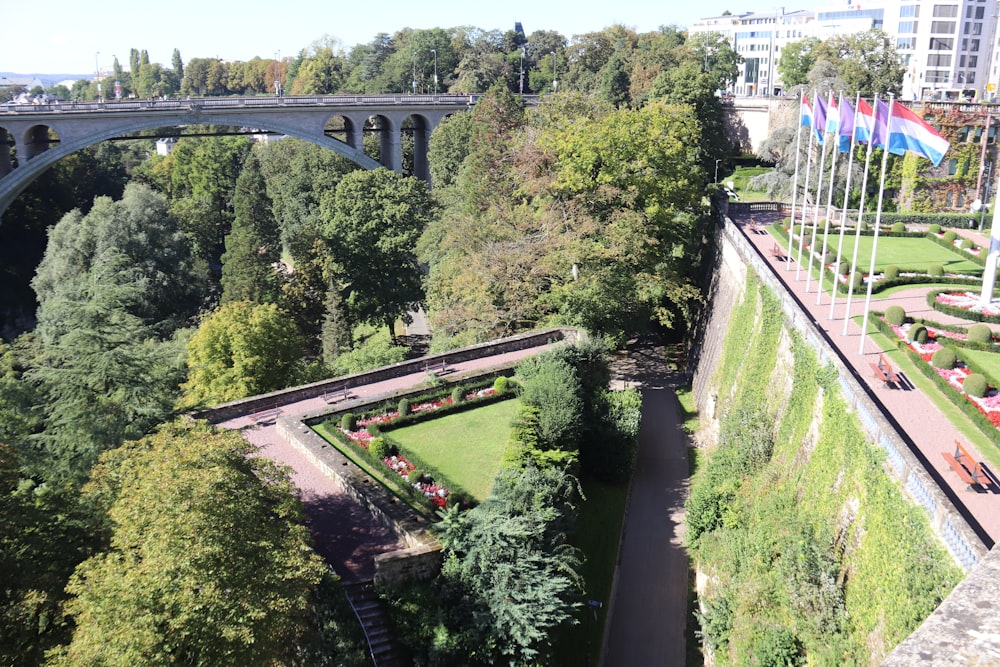 an aerial view of a park with a bridge in the background