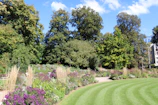 A clean and organized garden designed with lush green plants and colorful flowers.