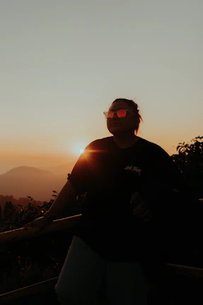 A sunset backdrop highlighting a model in OG Drip layered streetwear.