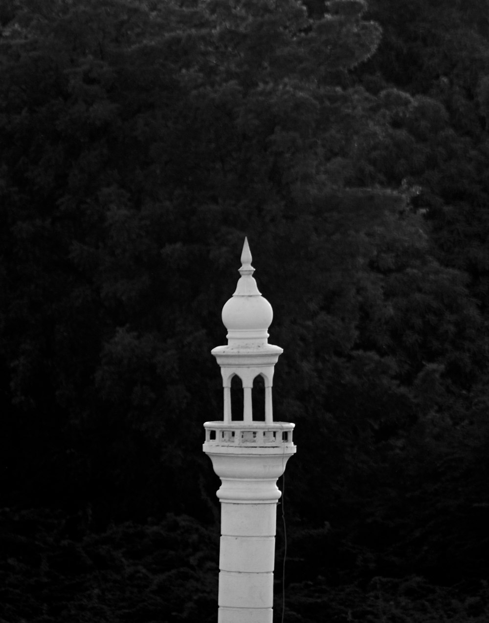 a tall white tower with a clock on top of it