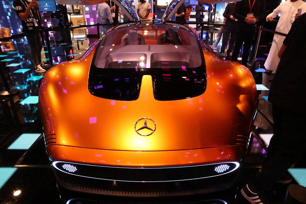 an orange sports car is on display at a show