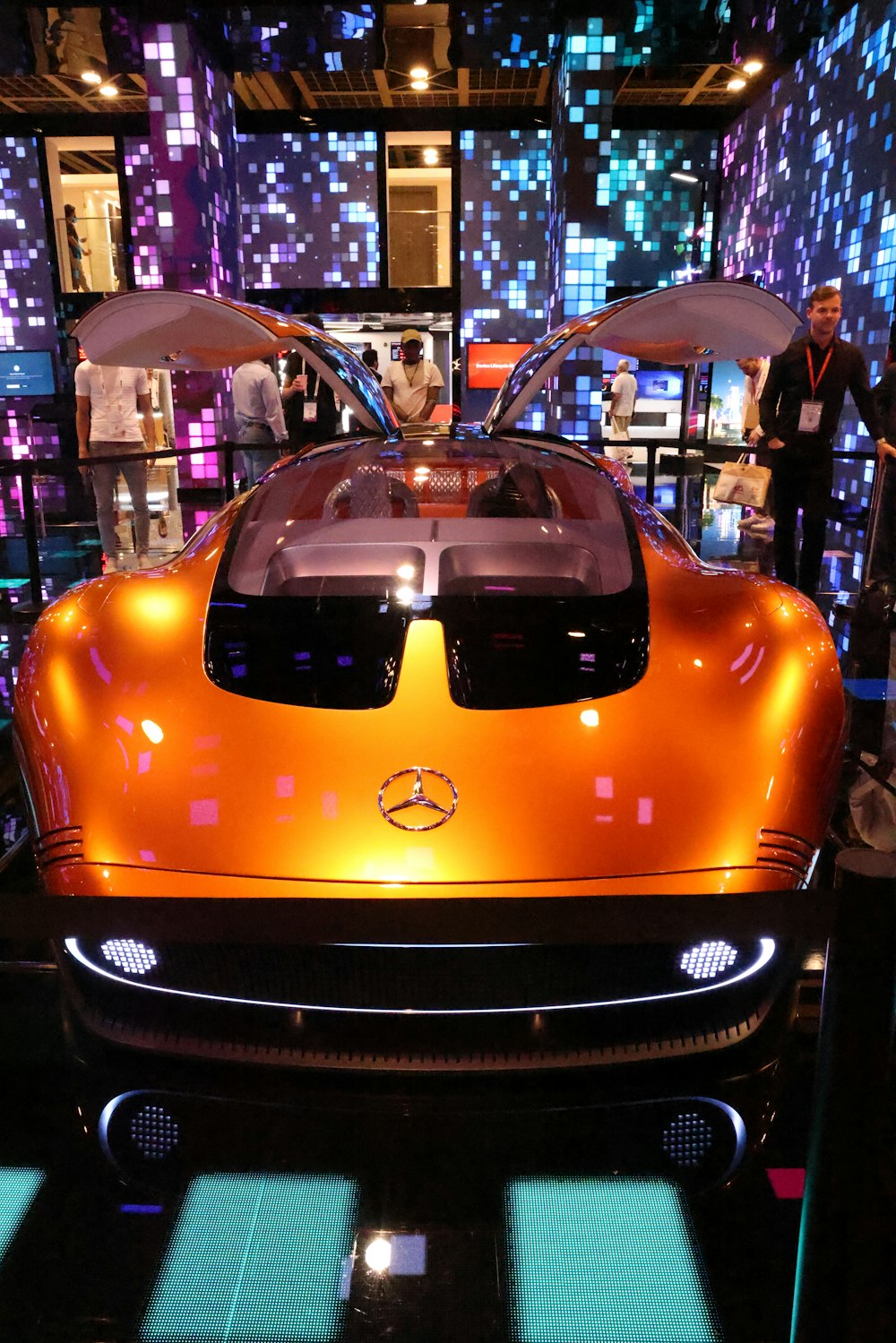 Une voiture de sport orange exposée dans un salon de l’auto