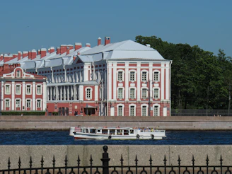 a large red and white building next to a body of water