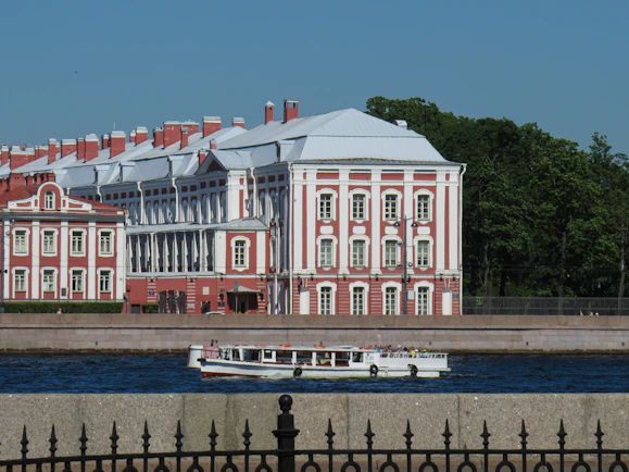 a large red and white building next to a body of water