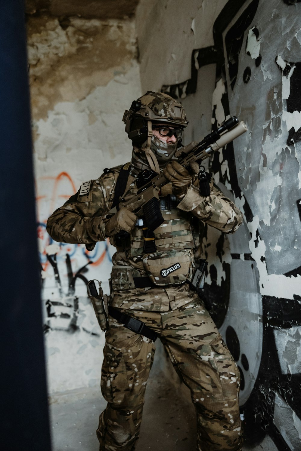 a man in camouflage holding a gun in his hand