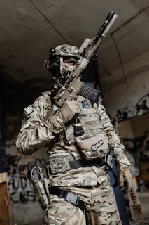 a man in camouflage holding a rifle in his hand
