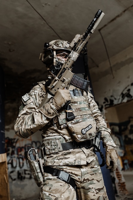 a man in camouflage holding a rifle in his hand