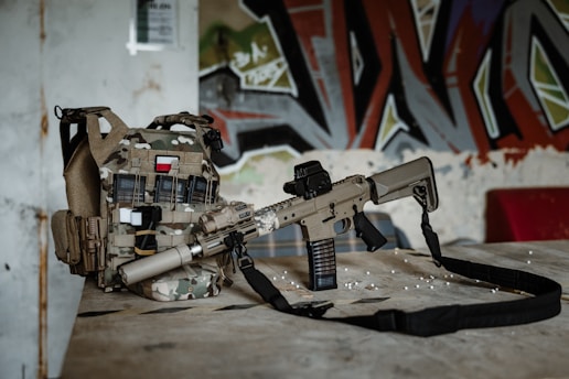 a rifle laying on top of a bag on a table