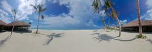 A panoramic view of a tropical beach resort with crystal-clear waters and palm trees swaying gently.