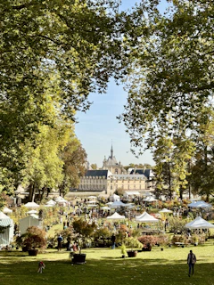 A lively cultural event taking place outdoors with people gathered near the historic château, enjoying music and conversation.