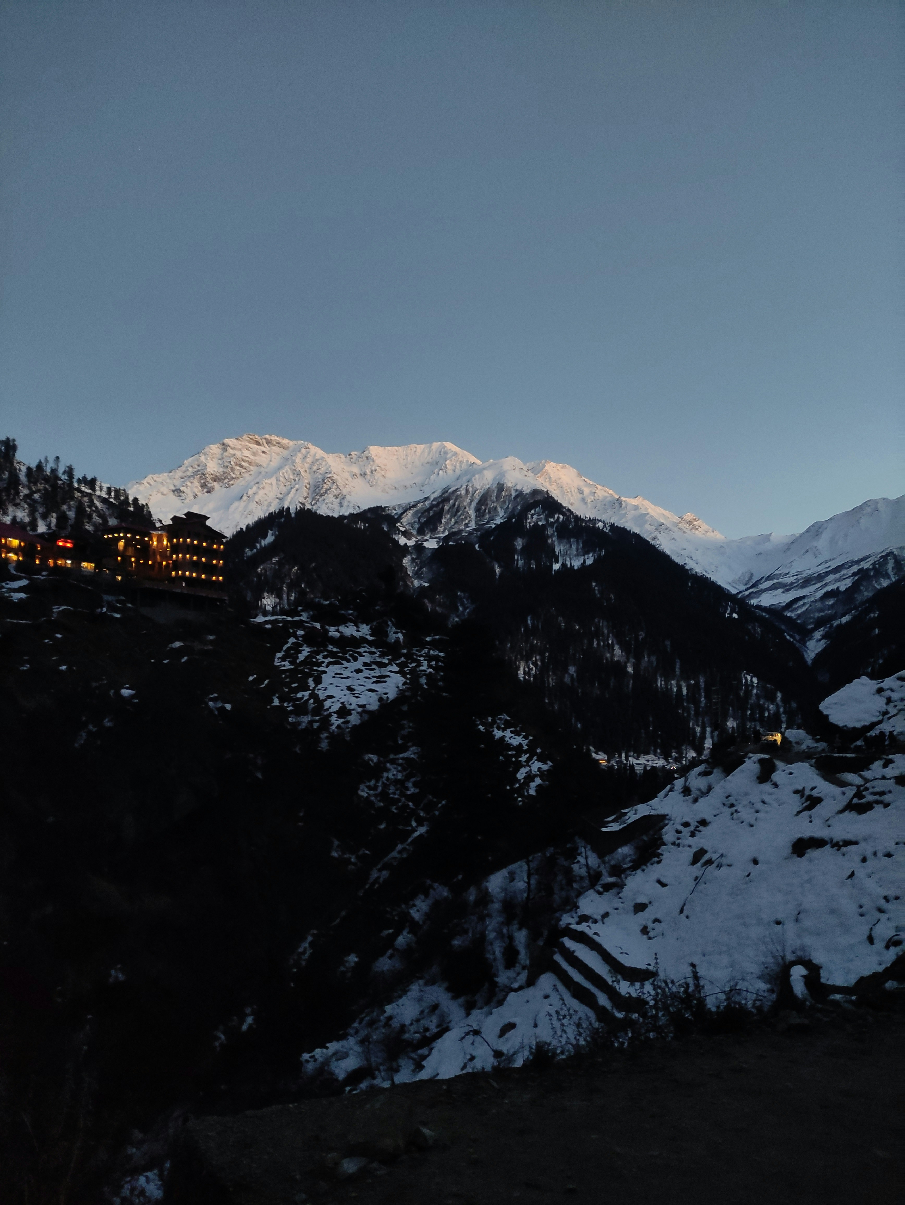 una montagna innevata con un hotel in lontananza