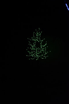 A glowing tree of light standing against a deep charcoal background, symbolizing a portal.