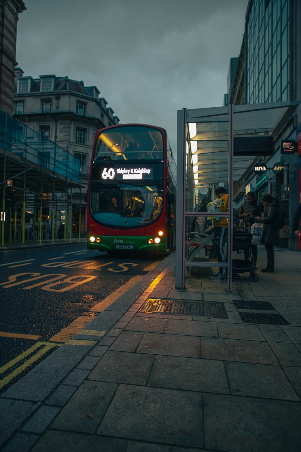 a red double decker bus driving down a street