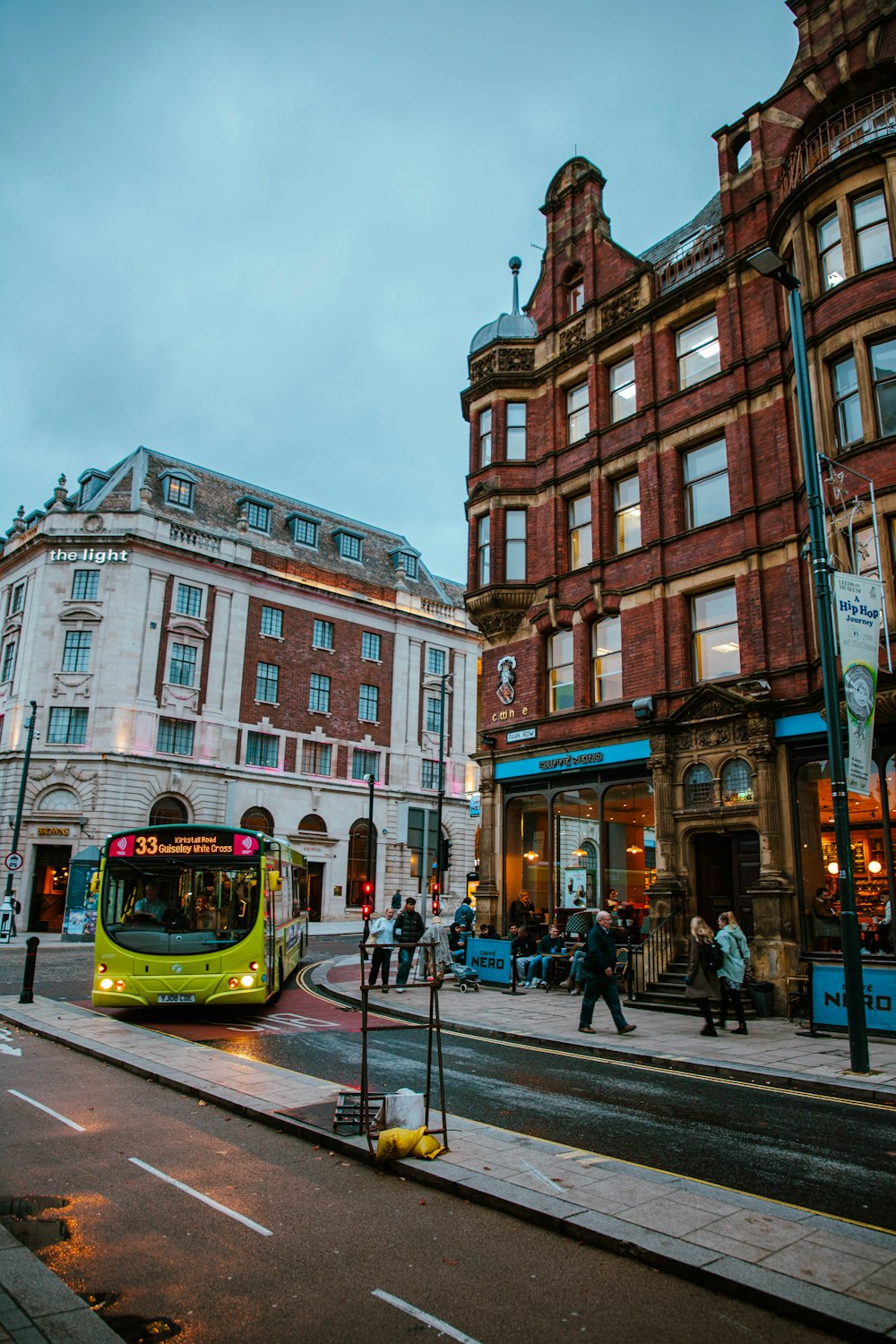 a yellow bus driving down a street next to tall buildings