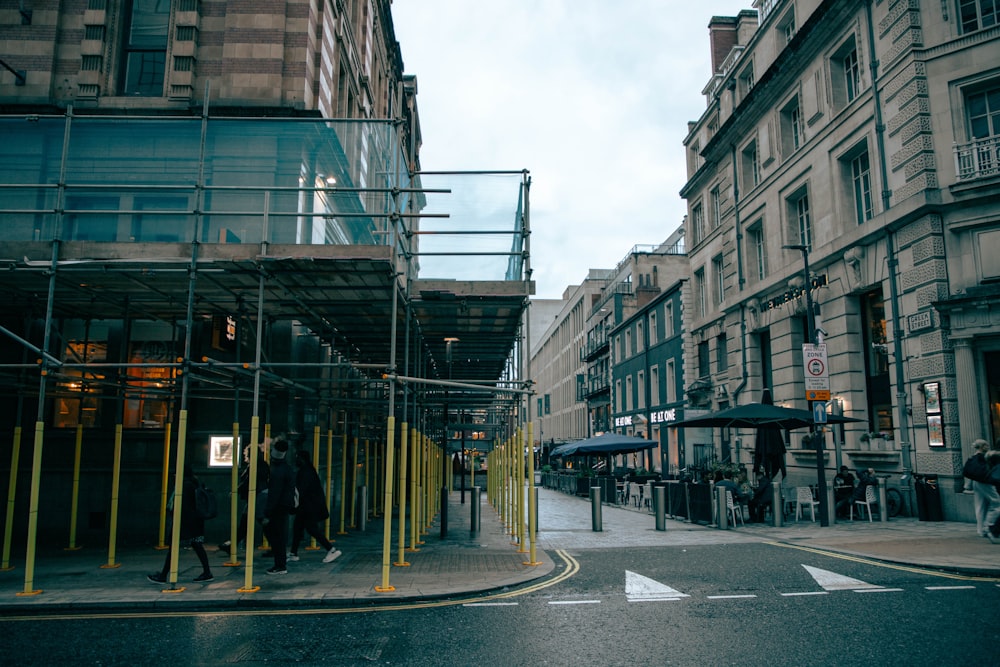 a man walking down a street next to tall buildings