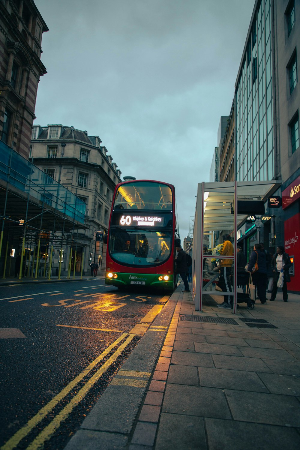 a red double decker bus on a city street