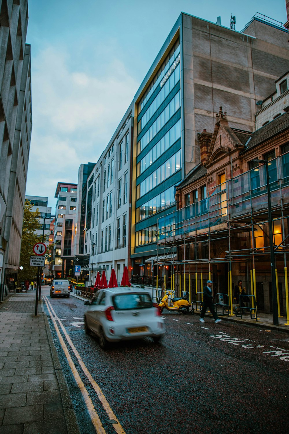 a car driving down a street next to tall buildings