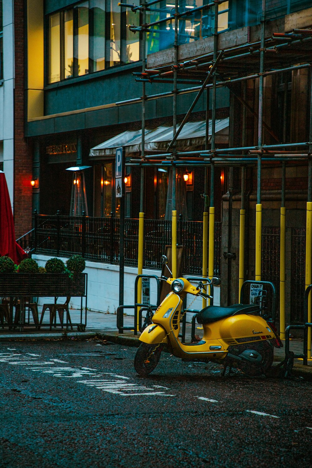 a yellow scooter parked in front of a restaurant