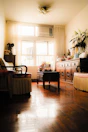 Spacious living room with vintage wooden furniture and soft cushions.