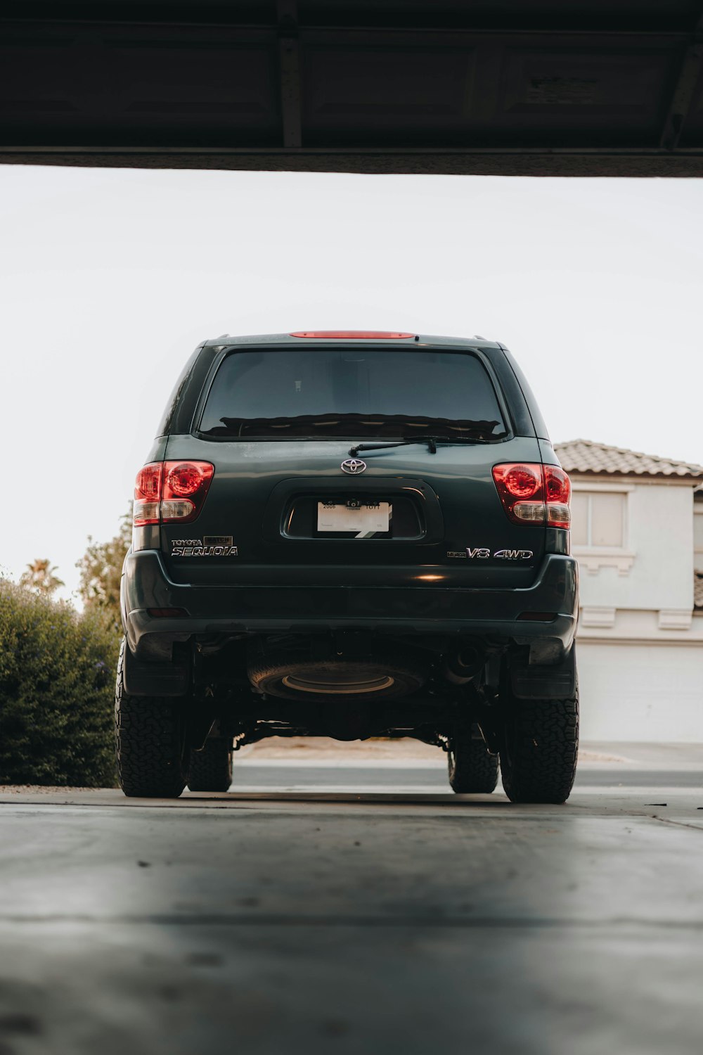 the back end of a black suv parked in a garage