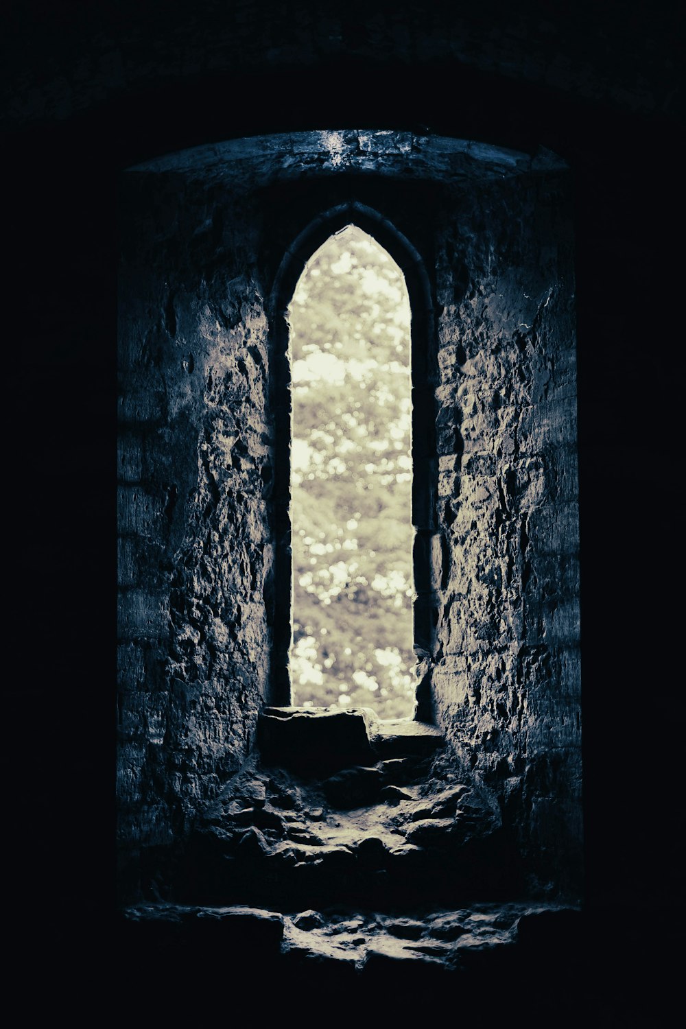 a window in a stone building with a sky background