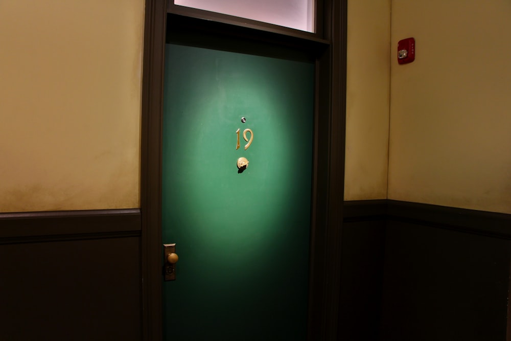 a green door in a room with a light on