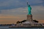 the statue of liberty stands in front of a body of water