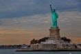 the statue of liberty stands in front of a body of water