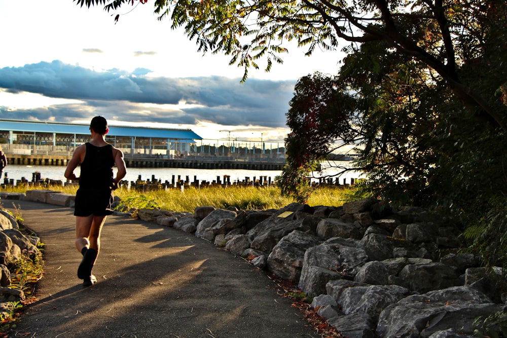 a man running down a path next to a lake