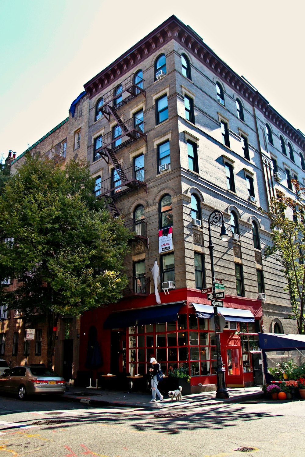 a tall building with a red awning next to a street