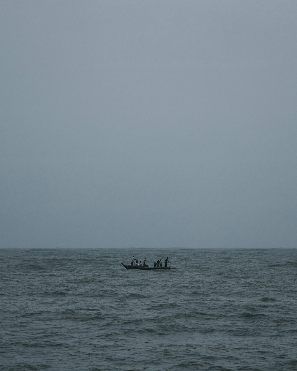 a group of people on a boat in the middle of the ocean