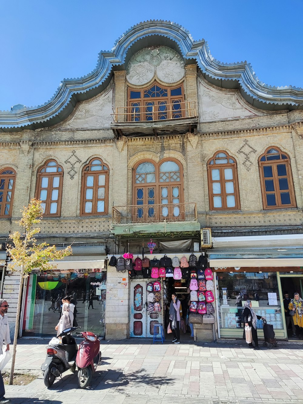 a large building with many windows and people walking around