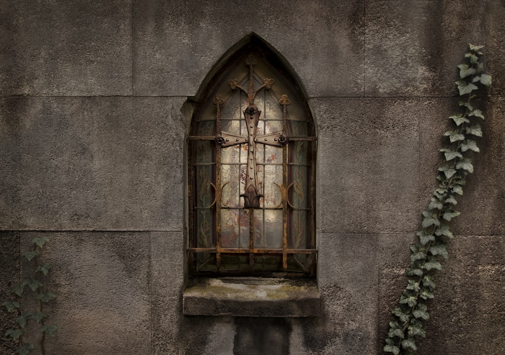 une fenêtre dans un mur de pierre sur laquelle pousse du lierre
