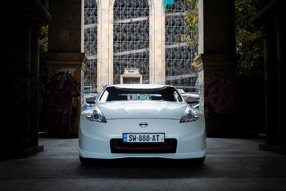 a white car parked in front of a building