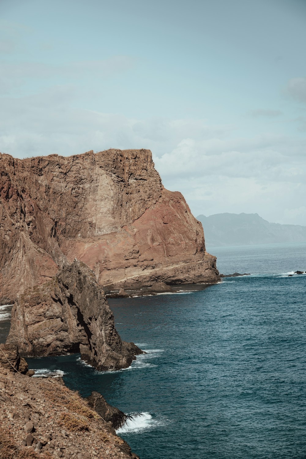 a large body of water near a rocky cliff