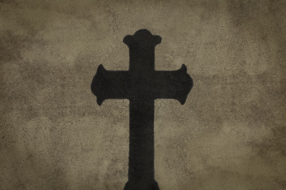 a cross on a wall with a grungy background