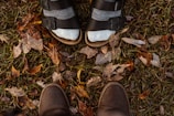 Casual feet wearing cozy slippers walking through a leafy park path.