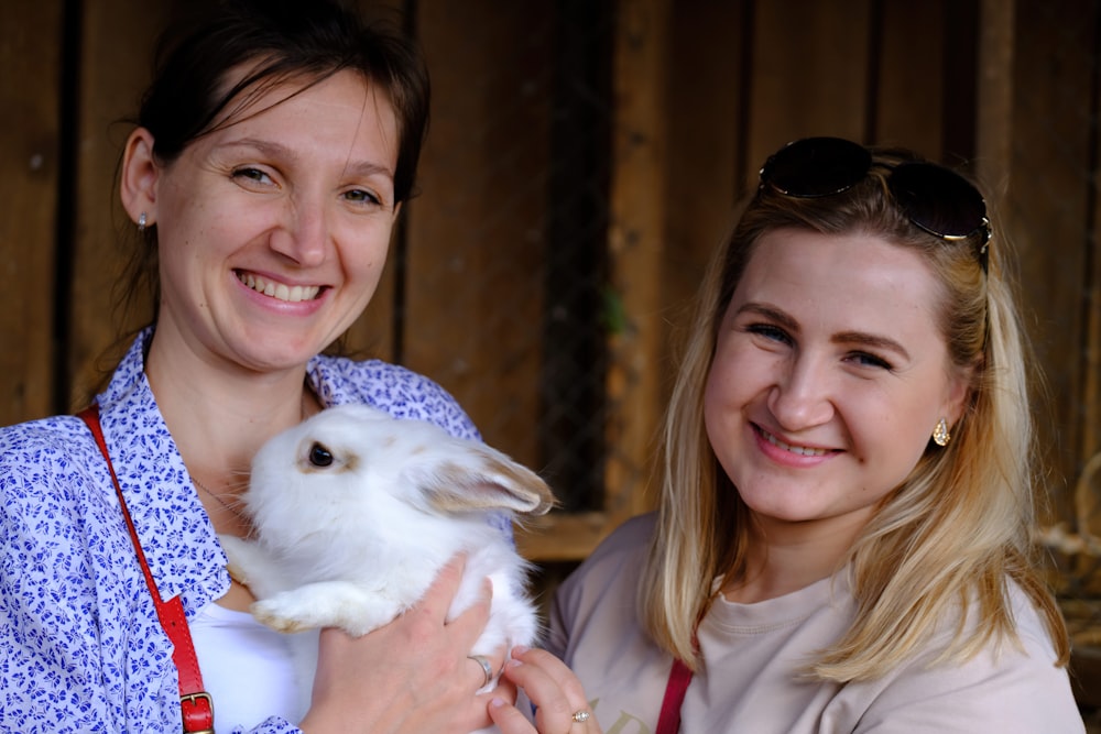 a woman holding a white rabbit in her arms