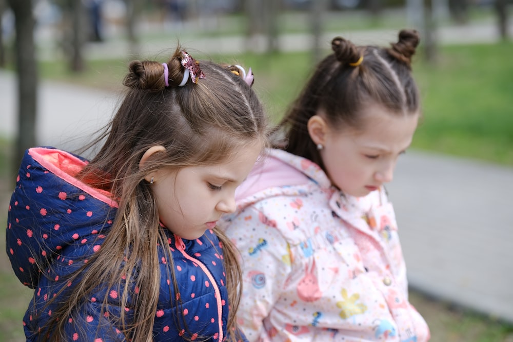 two little girls sitting on a park bench