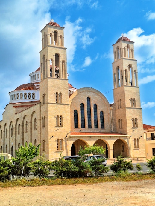 a large building with two towers and a sky background