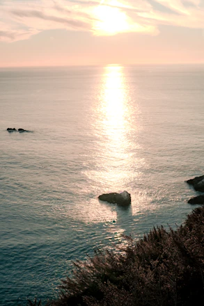 A serene view of the Israeli coastline with a golden sunset reflecting on the sea.