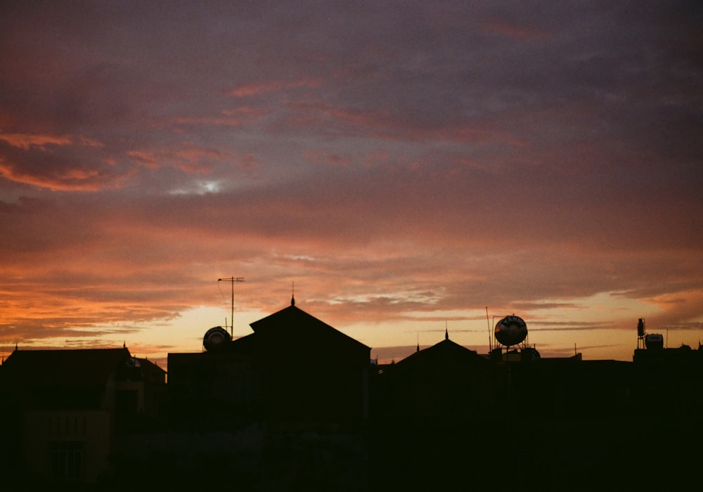 a sunset view of some buildings and a clock tower