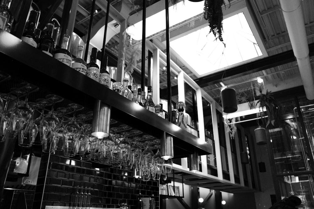 a black and white photo of a bar filled with wine glasses